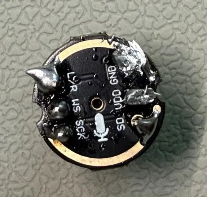 第一次焊接后的 INMP441 标注面，六处焊锡的形状和体积不一致，部分呈较大的尖状或块状堆积。